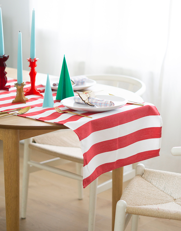Camino de mesa ELF para mesas de Navidad está diseñado en tela de rayas rojas y blancas para decoraciones modernas de Navidad. ¡Descúbrelo!