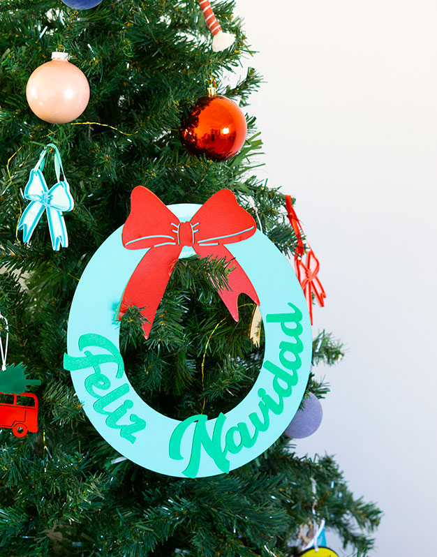 Corona circular Feliz Navidad en colores para decorar la puerta, ventanas o para colgar de una pared. ¡Da la bienvenida a tus familiares!